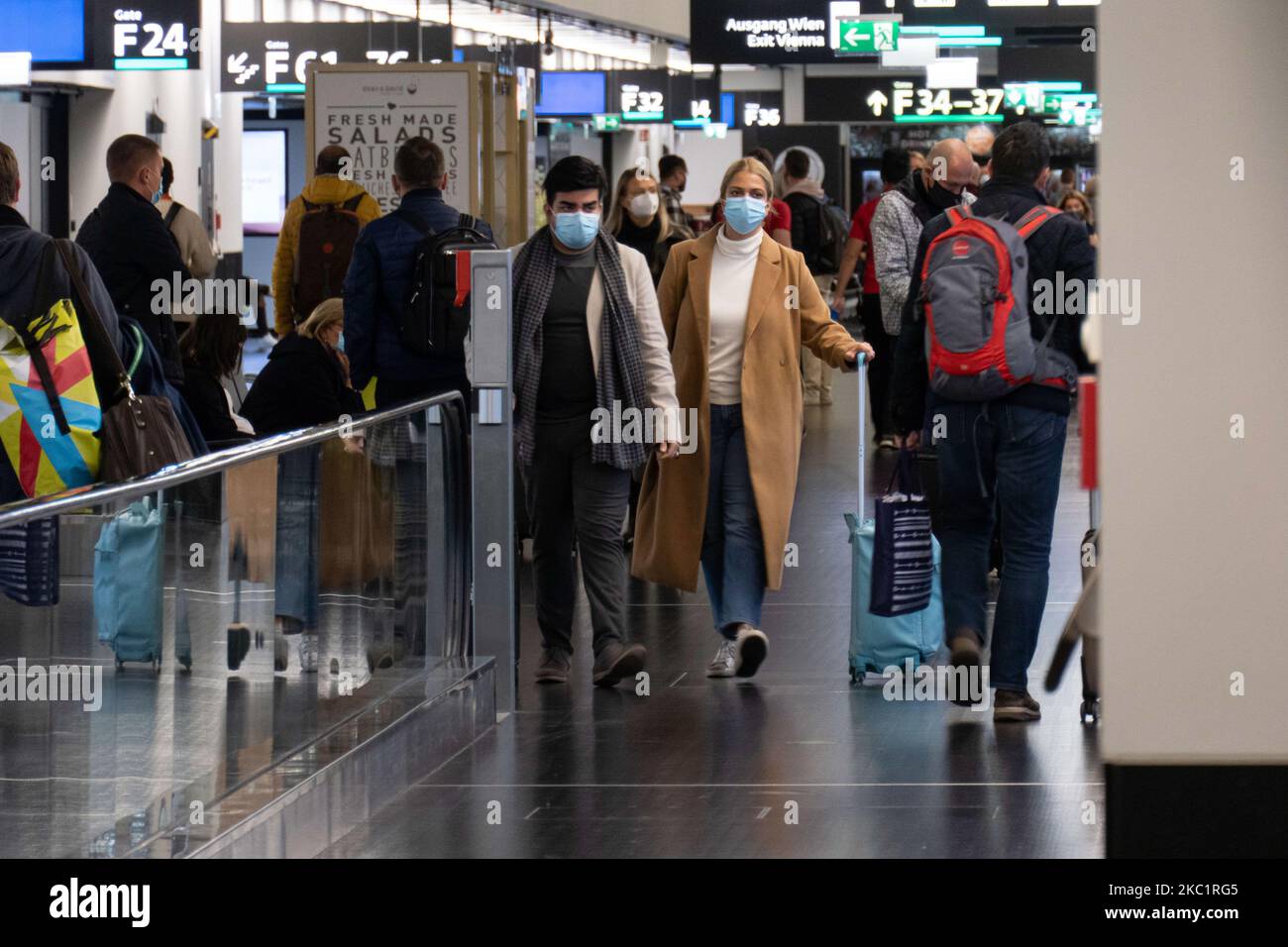 Passengers wearing facemasks, face shields, gloves and other safety measures are seen in the airport terminal, at the F Gates area of Vienna International Airport VIE LOWW - Flughafen Wien-Schwechat serving the Austrian Capital but also Bratislava as it is 55km away from the Slovak city during the Covid-19 Coronavirus pandemic era. There is a second wave coming while cases are increasing, facemask become mandatory, social distancing measures and disinfecting hand sanitizer are everywhere while new lockdowns or mini lockdown in specific areas like Greece or partial lockdown like the Netherlands Stock Photo