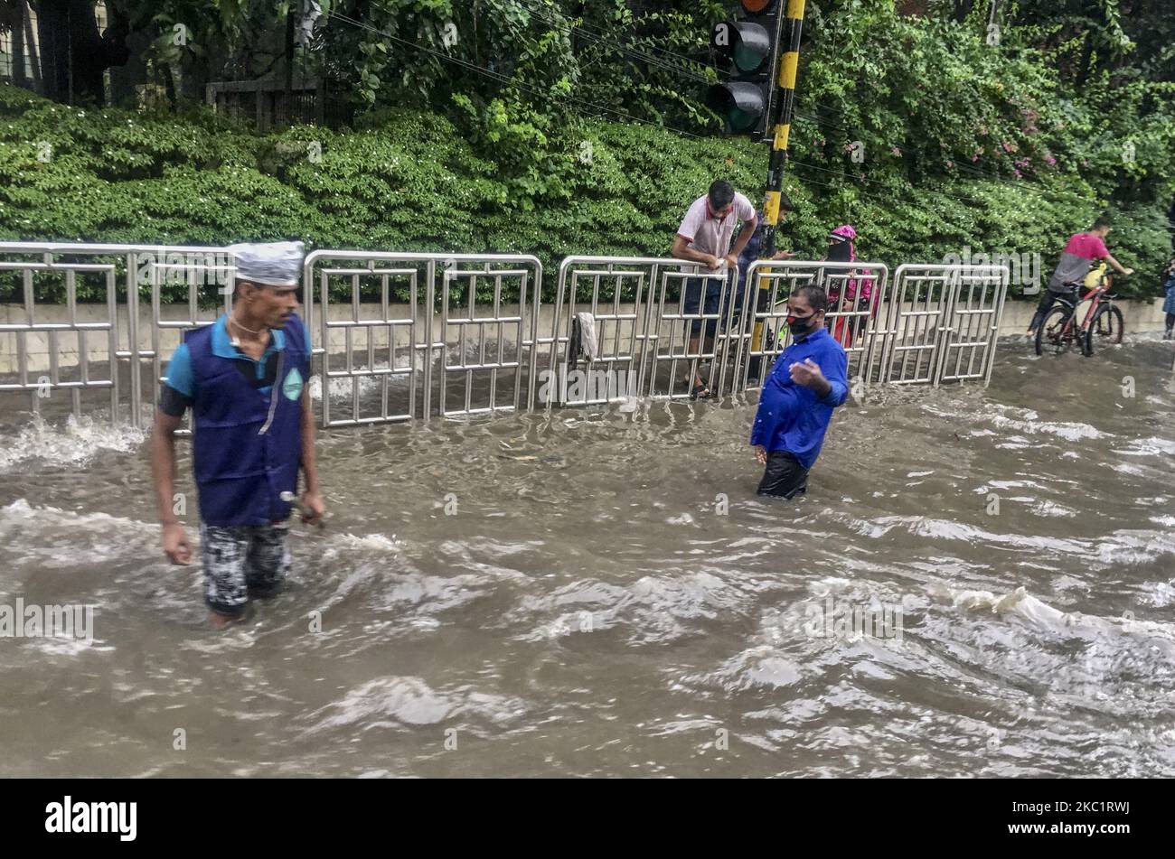 Vehicles try driving and citizens are walking through the water logging