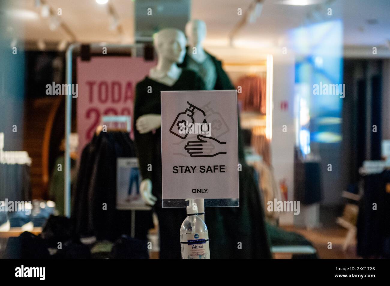 Inside of a clothes store is places a Corona measures warning sign