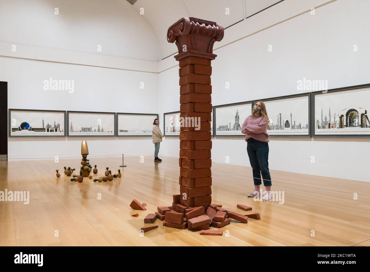 (EDITOR'S NOTE: Editorial Use Only)Gallery staff member looks at Unsupported Support (1987) and Architectural Fragment/ Third column (1986) by Edward Allington (1951-2017) with From the Birth of Paradise (1983) installation in the background during a photocall to promote opening of new displays at Tate Britain as part of the museum’s three collection routes designed to allow visitors to move around the gallery in a one way system due to coronavirus restrictions on 15 October 2020 in London, England. (Photo by WIktor Szymanowicz/NurPhoto) Stock Photo