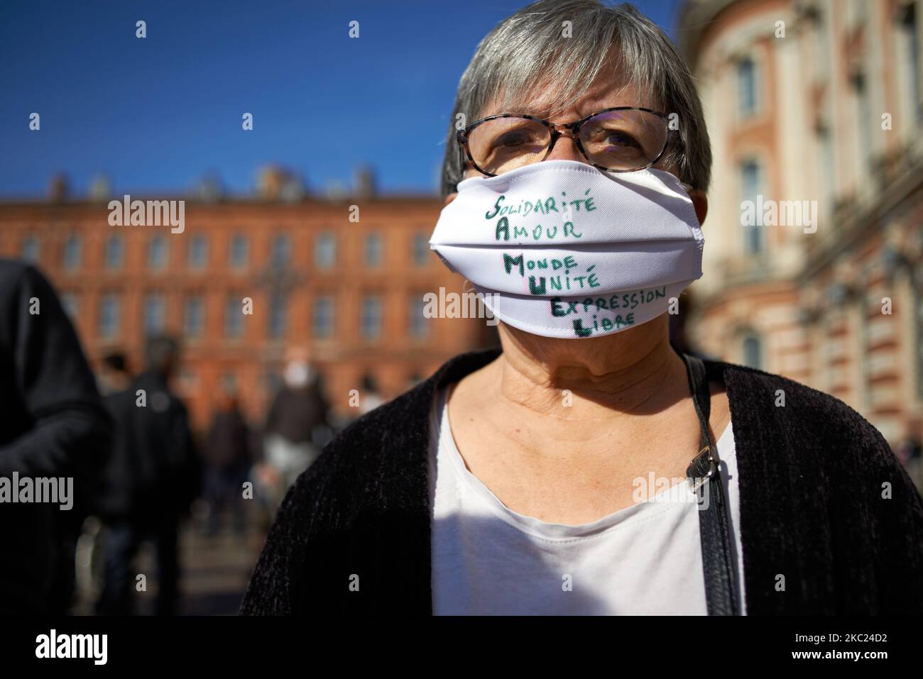 A teache wears a face mask reading 'Solidarity Love World Unity Freedom Expression' which in French gives 'S.A.M.U.E.L'. After the killing of Samuel Paty, teacher of Geography-History, in Conflans-Sainte-Honorine (Yvelines) on October 16th several thousands of people gathered on the main square of Toulouse, in front of the townhall, the Capitole, to defend freedom of expression and to pay tribute to Samuel. Some people came with a cover of Charlie Hebdo as the teacher has been killed after showing at his pupils the Charlie Hebdo' caricatures of Muhammed. The killer has been killed by French po Stock Photo