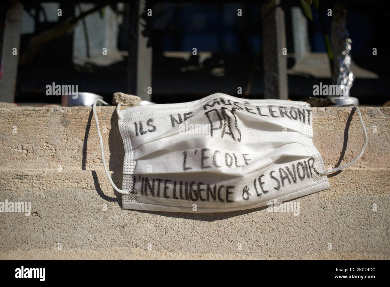 Someone has put his facemask on an improvised altar, it reads 'They won't muzzle school, intelligence and knowledge'. After the killing of Samuel Paty, teacher of Geography-History, in Conflans-Sainte-Honorine (Yvelines) on October 16th several thousands of people gathered on the main square of Toulouse, in front of the townhall, the Capitole, to defend freedom of expression and to pay tribute to Samuel. Some people came with a cover of Charlie Hebdo as the teacher has been killed after showing at his pupils the Charlie Hebdo' caricatures of Muhammed. The killer has been killed by French polic Stock Photo