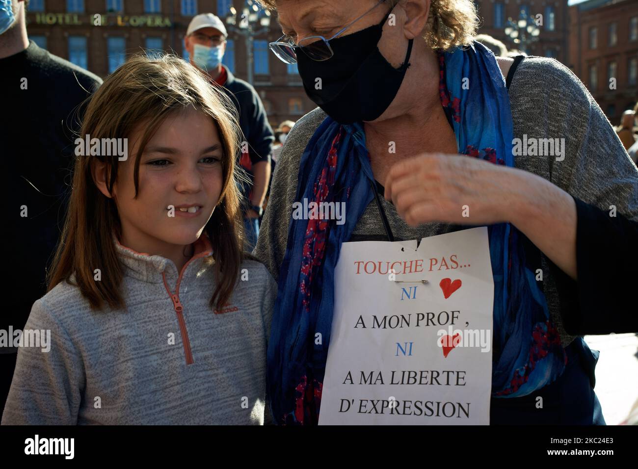 A grandmothuer with her granddaughte keeps a placard reading 'Don't touch nor my teacher nor my freedom of expression'. After the killing of Samuel Paty, teacher of Geography-History, in Conflans-Sainte-Honorine (Yvelines) on October 16th several thousands of people gathered on the main square of Toulouse, in front of the townhall, the Capitole, to defend freedom of expression and to pay tribute to Samuel. Some people came with a cover of Charlie Hebdo as the teacher has been killed after showing at his pupils the Charlie Hebdo' caricatures of Muhammed. The killer has been killed by French pol Stock Photo