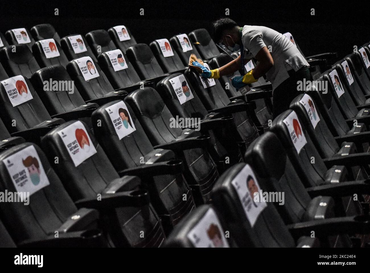A man disinfects the chairs at SM Cinema in Santa Rosa, Laguna in the Philippines on October 18, 2020.(Photo by Lisa Marie David/NurPhoto) Stock Photo