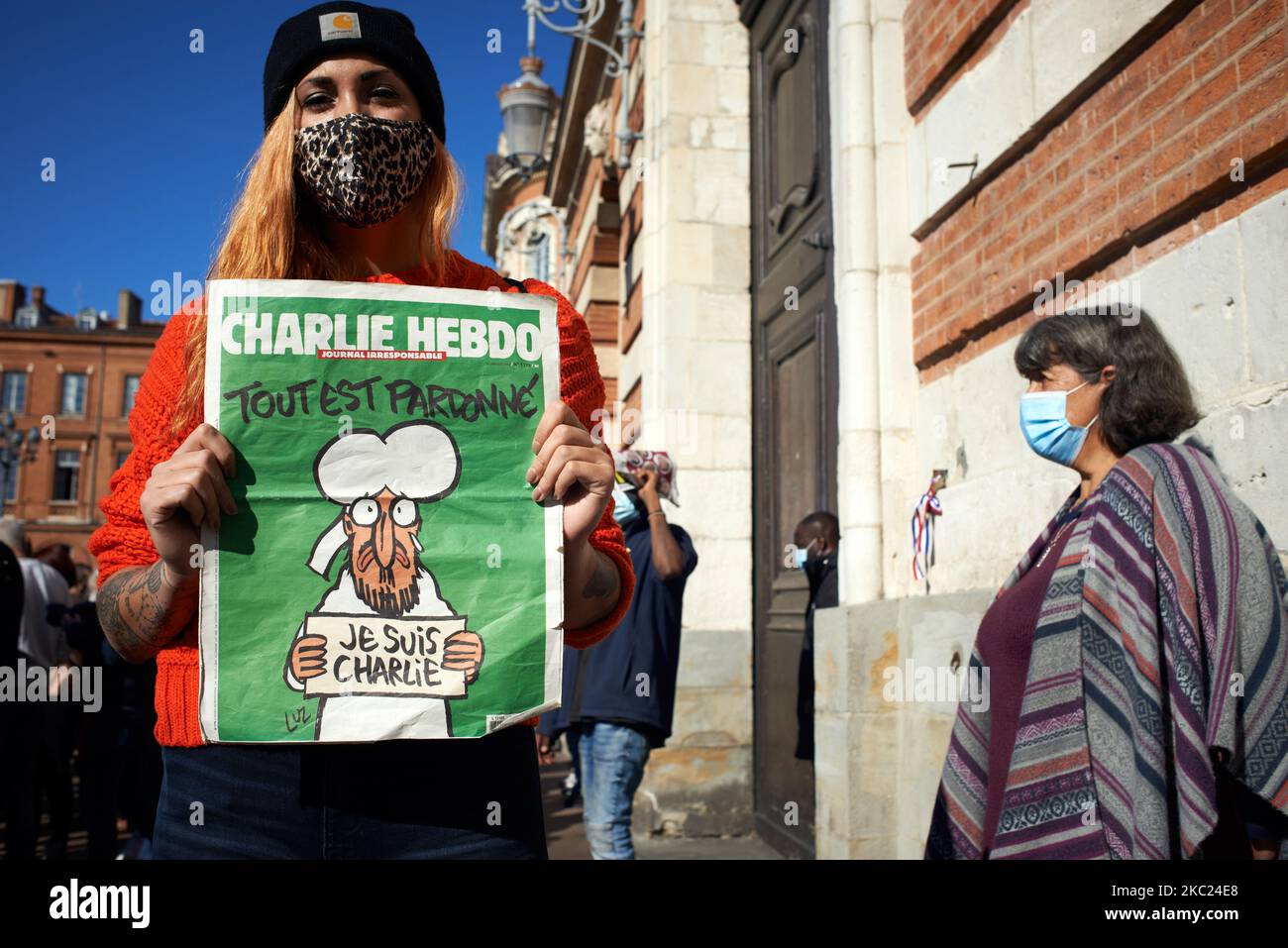 A woman holds a cover of the Charlie Hebdo newspaper reading 'All is forgiven' with a caricature of propher Muhammed. After the killing of Samuel Paty, teacher of Geography-History, in Conflans-Sainte-Honorine (Yvelines) on October 16th several thousands of people gathered on the main square of Toulouse, in front of the townhall, the Capitole, to defend freedom of expression and to pay tribute to Samuel. Some people came with a cover of Charlie Hebdo as the teacher has been killed after showing at his pupils the Charlie Hebdo' caricatures of Muhammed. The killer has been killed by French polic Stock Photo