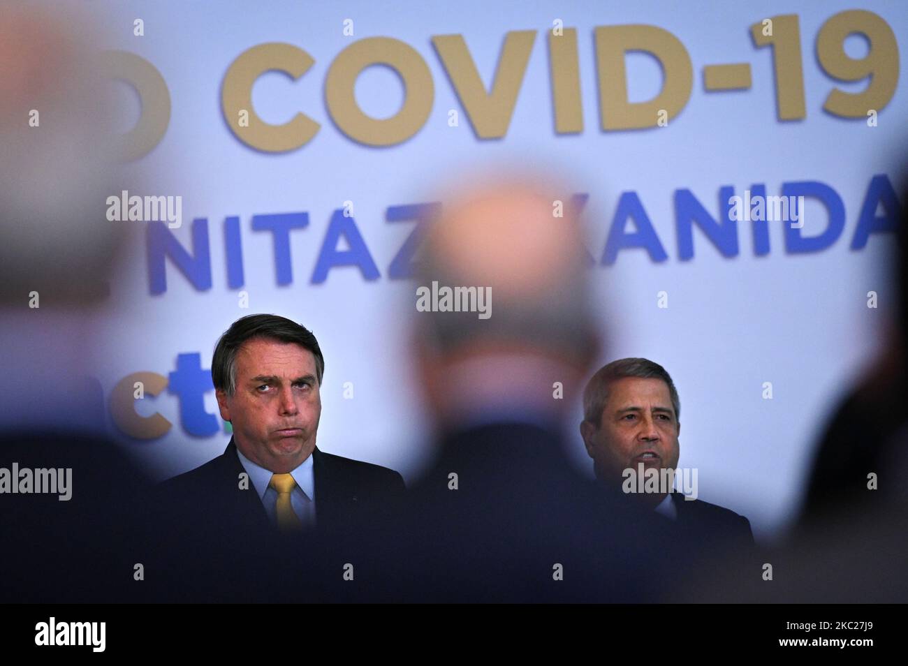 Brazil's President Jair Bolsonaro coughs next to Brazil's Chief of Staff Minister Walter Braga Netto during the COVID-19 Clinical Study result announcement at the Planalto Palace in Brasilia, Brazil, on October 19, 2020. (Photo by Andre Borges/NurPhoto) Stock Photo