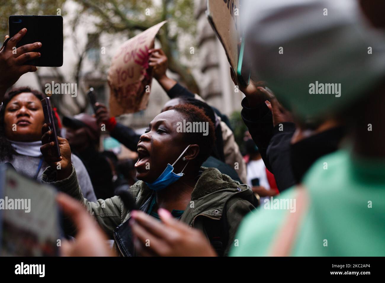 Activists protesting police brutality by the Nigerian Special Anti-Robbery Squad (SARS) demonstrate outside the Nigerian High Commission on Great Scotland Yard in London, England, on October 21, 2020. SARS has been accused of extrajudicial killings, extortion and torture, prompting demonstrations across Nigeria that have seen at least 56 people killed by Nigerian security forces in recent weeks, according to human rights group Amnesty International. The dead include at least 12 at two locations in Lagos - Lekki and Alausa - on Tuesday, it said, among some 38 people killed yesterday across the  Stock Photo