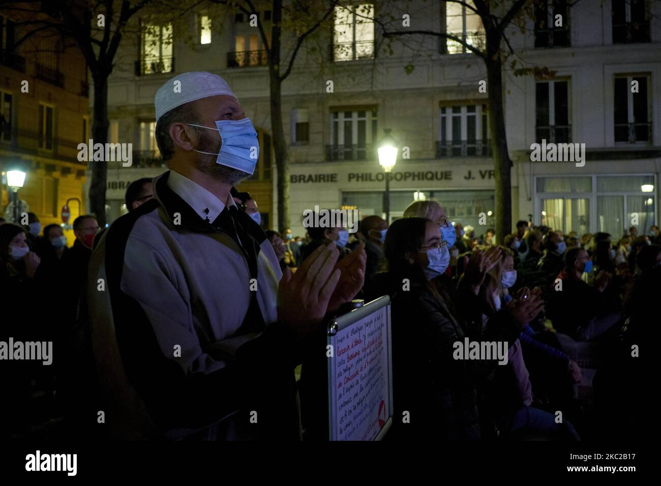 People gathered on the Place de la Sorbonne in Paris on October 21, 2020, to watch a live broadcast on a giant screen of the national tribute to the french teacher Samuel Paty, a teacher at the College du Bois d'Aulne in Conflans-Sainte-Honorine, who was beheaded by an islamist. Samuel Paty was killed for having shown caricatures of the Prophet Mohammed published by Charlie Hebdo to his pupils during a course on freedom of expression. (Photo by Adnan Farzat/NurPhoto) Stock Photo
