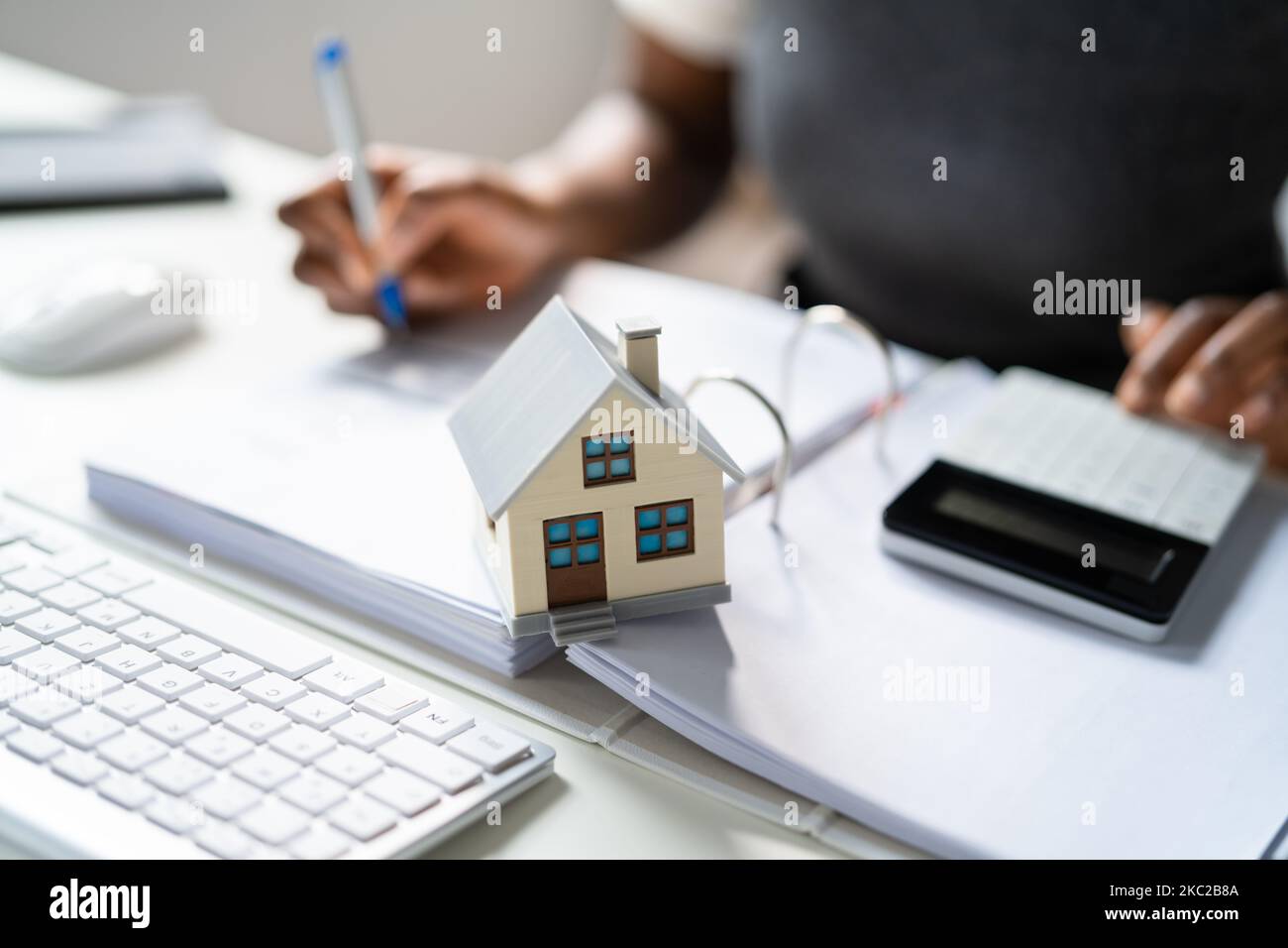 Person Hand Doing Property Tax Calculation Using Calculator Of House
