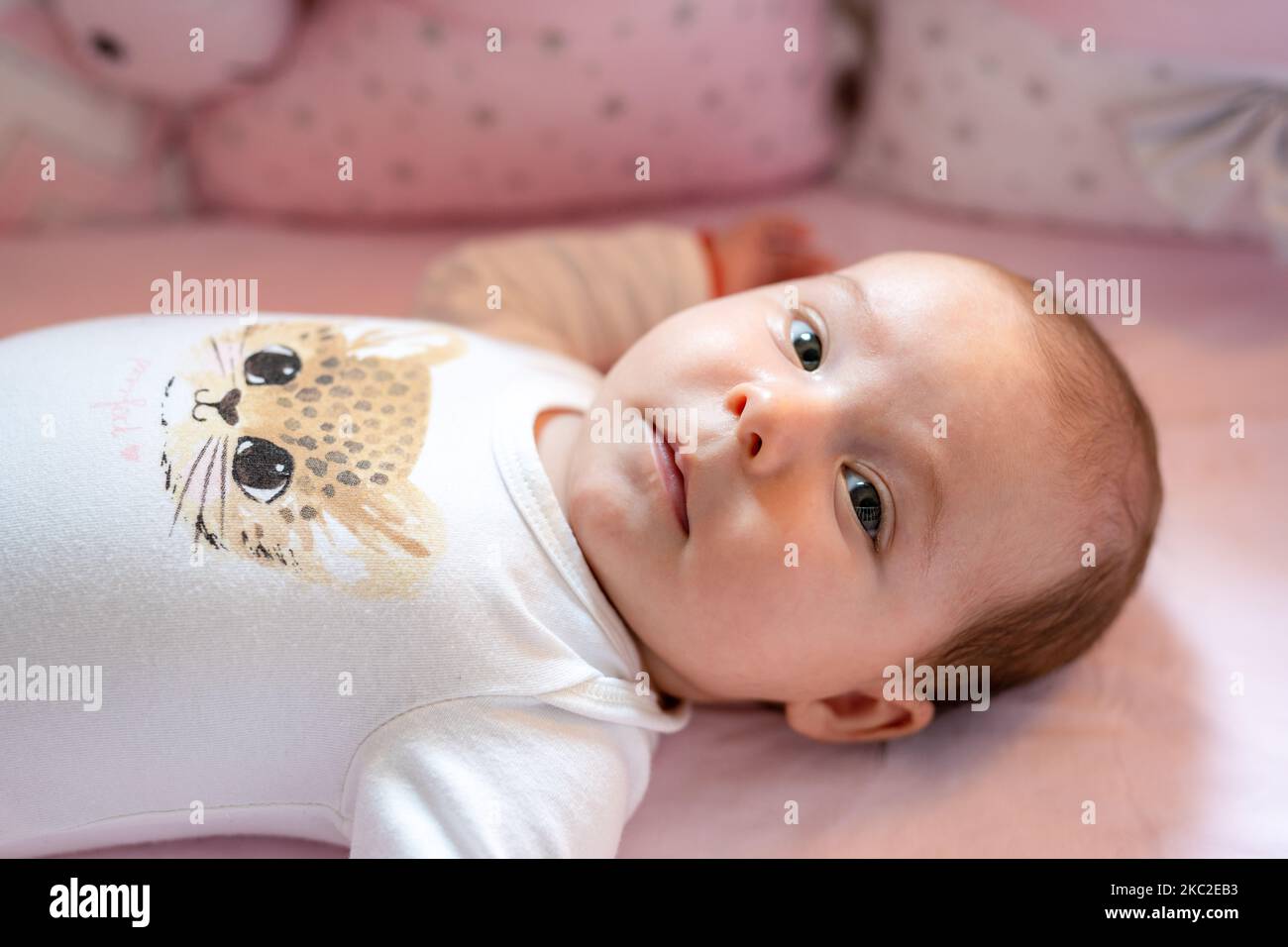 New born baby girl on texture blanket, lying in bed opened eyes Stock