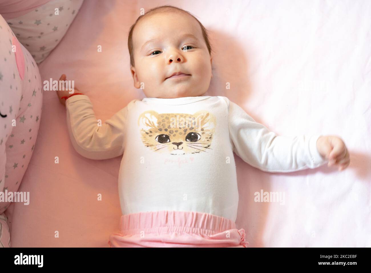 New born baby girl on texture blanket, lying in bed opened eyes Stock