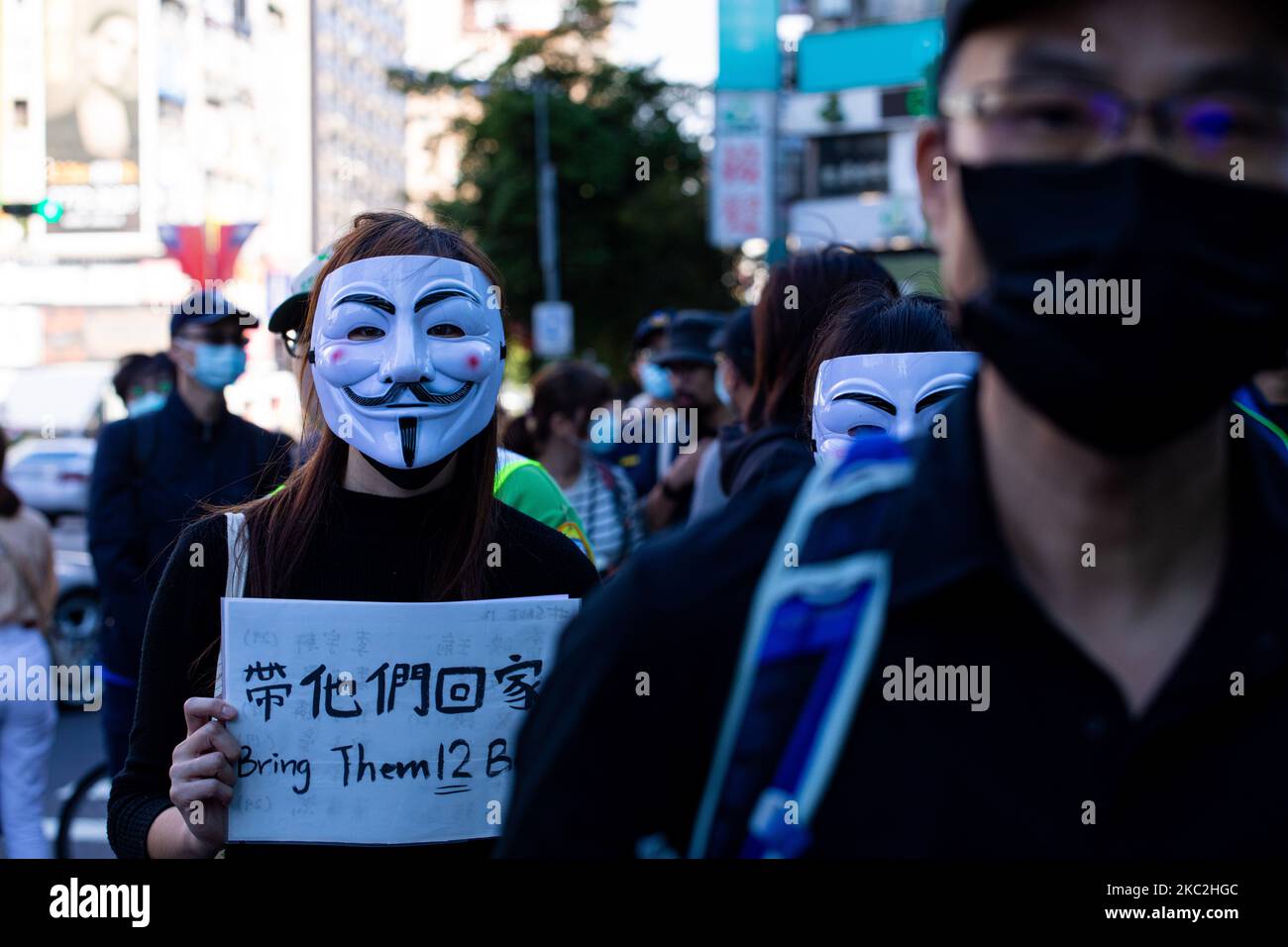 A protester wears Vendetta mask during the march to demand the release of 12 Hong Kong detainees in Taipei, Taiwan, on October 25, 2020. Hundreds marched in Taiwan's capital on Sunday to demand the release of 12 Hong Kong anti-government protesters who were allegedly traveling illegally by boat to Taiwan when Chinese authorities captured and detained them in August. (Photo by Annabelle Chih/NurPhoto) Stock Photo