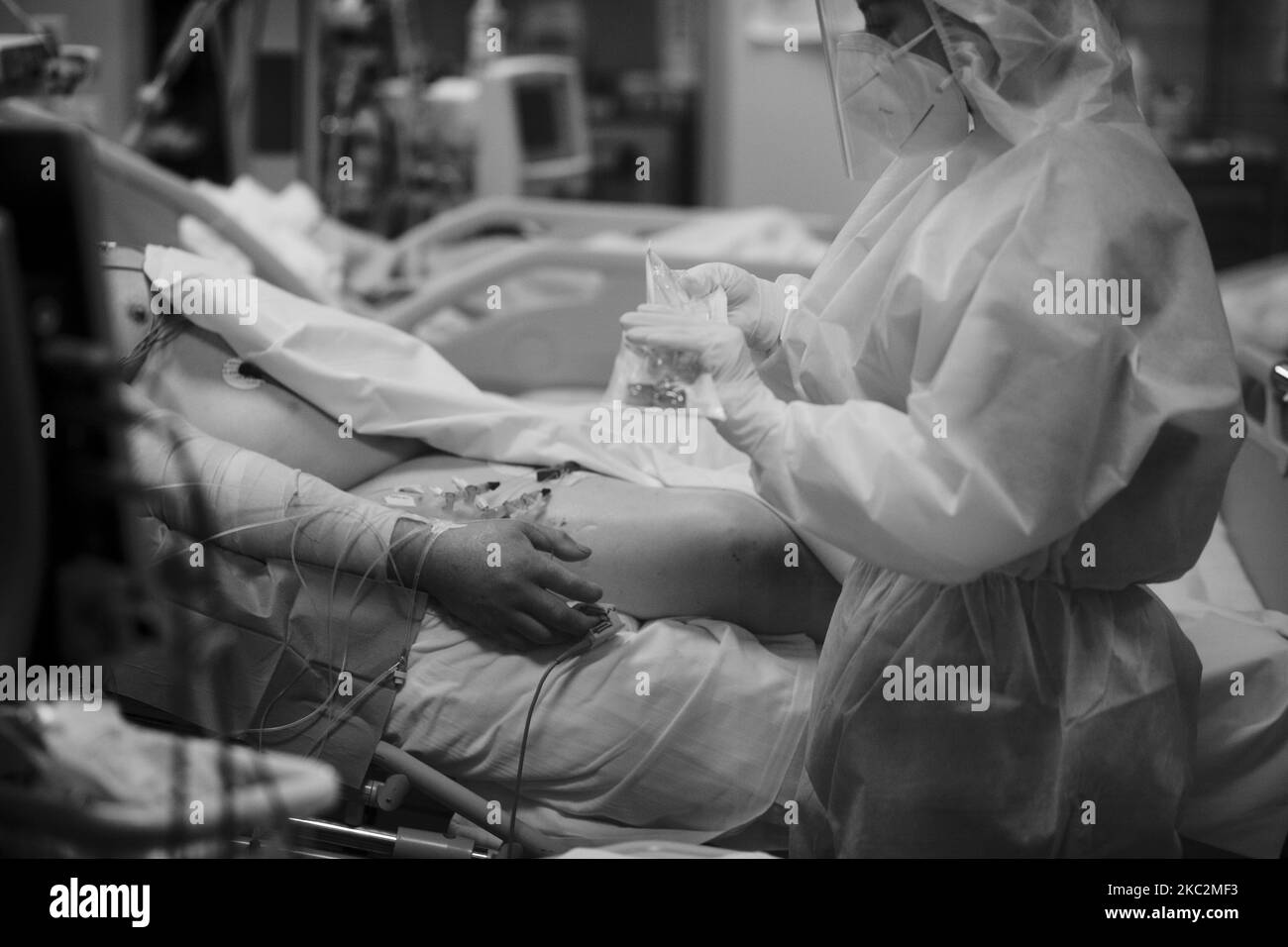 (EDITOR'S NOTE: IMAGE HAS BEEN CONVERTED TO BLACK AND WHITE) A medical worker in personal protective equipment (PPE) tends to a patient in the COVID level-3, Intensive Care Unit (ICU) for novel coronavirus, COVID-19 cases, at the Casal Palocco hospital, near Rome on October 26, 2020. .According to Ministry of Health there has been 21,273 infections from Covid-19 in the last 24 hours out of 161,880 tampons carried out. 128 deaths and 80 additional patients admitted to intensive care units. (Photo by Christian Minelli/NurPhoto) Stock Photo