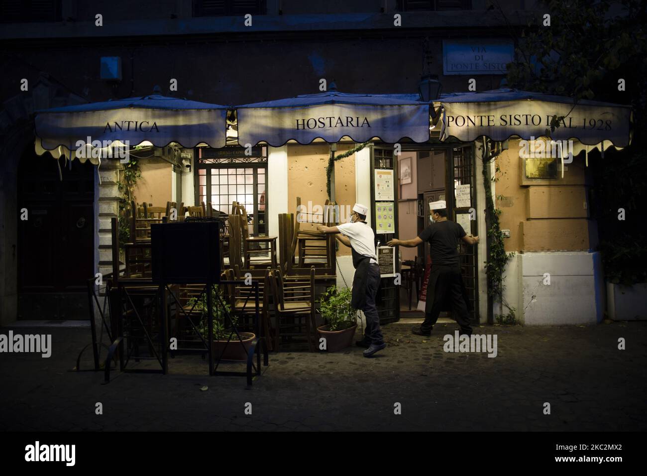 Staffers close a restaurant in Rome Monday Oct. 26 2020. For at