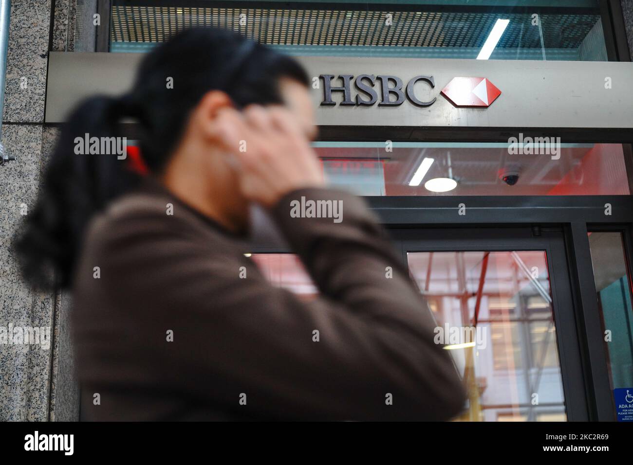 A person wearing a mask, walks past HSBC Bank branch. HSBC has warned it could start charging for 'basic banking services' after reporting a 35% fall in pre-tax profits for the three months to the end of September. New York City continues Phase 4 of re-opening following restrictions imposed to slow the spread of coronavirus on October 27, 2020 in New York City. The fourth phase allows outdoor arts and entertainment, sporting events without fans and media production. (Photo by John Nacion/NurPhoto) Stock Photo