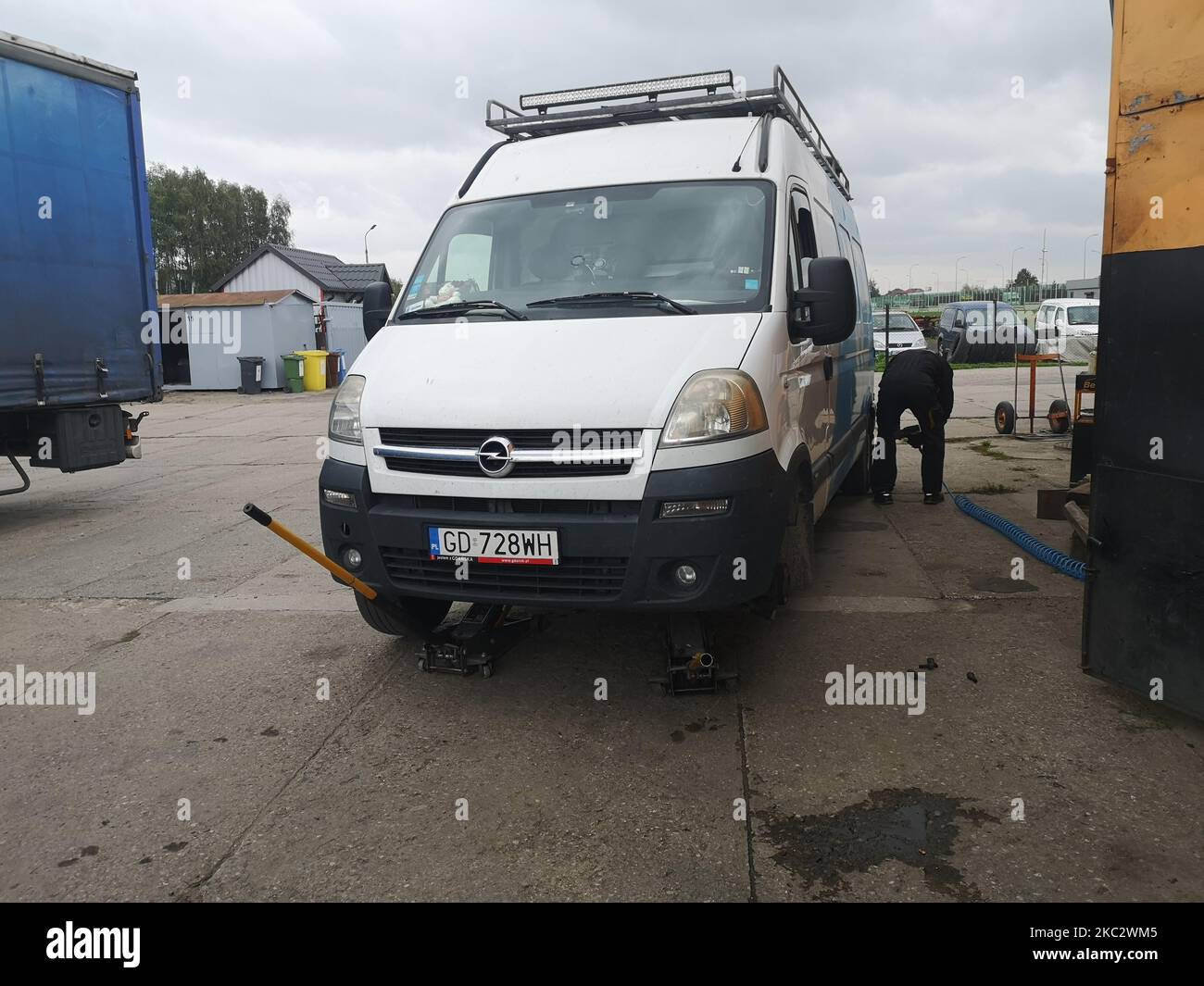 Opel Movano self-converted camper van with huge LED-bar light on the roof  rack during the seasonal tire change lifted on workshop lifts in the tire  service is seen in Gdansk, Poland on