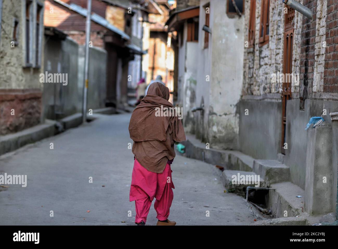 A woman walks through a narrow lane in District Baramulla, Jammu and Kashmir, India on 30 October 2020. As the anger grows in Jammu and Kashmir over the new land laws, which allow any Indian citizen to buy land in the Union territory, the separatist Hurriyat Conference on Wednesday broke its silence and called for a one-day shutdown on October 31 to protest the â€œanti-people movesâ€ by New Delhi. (Photo by Nasir Kachroo/NurPhoto) Stock Photo