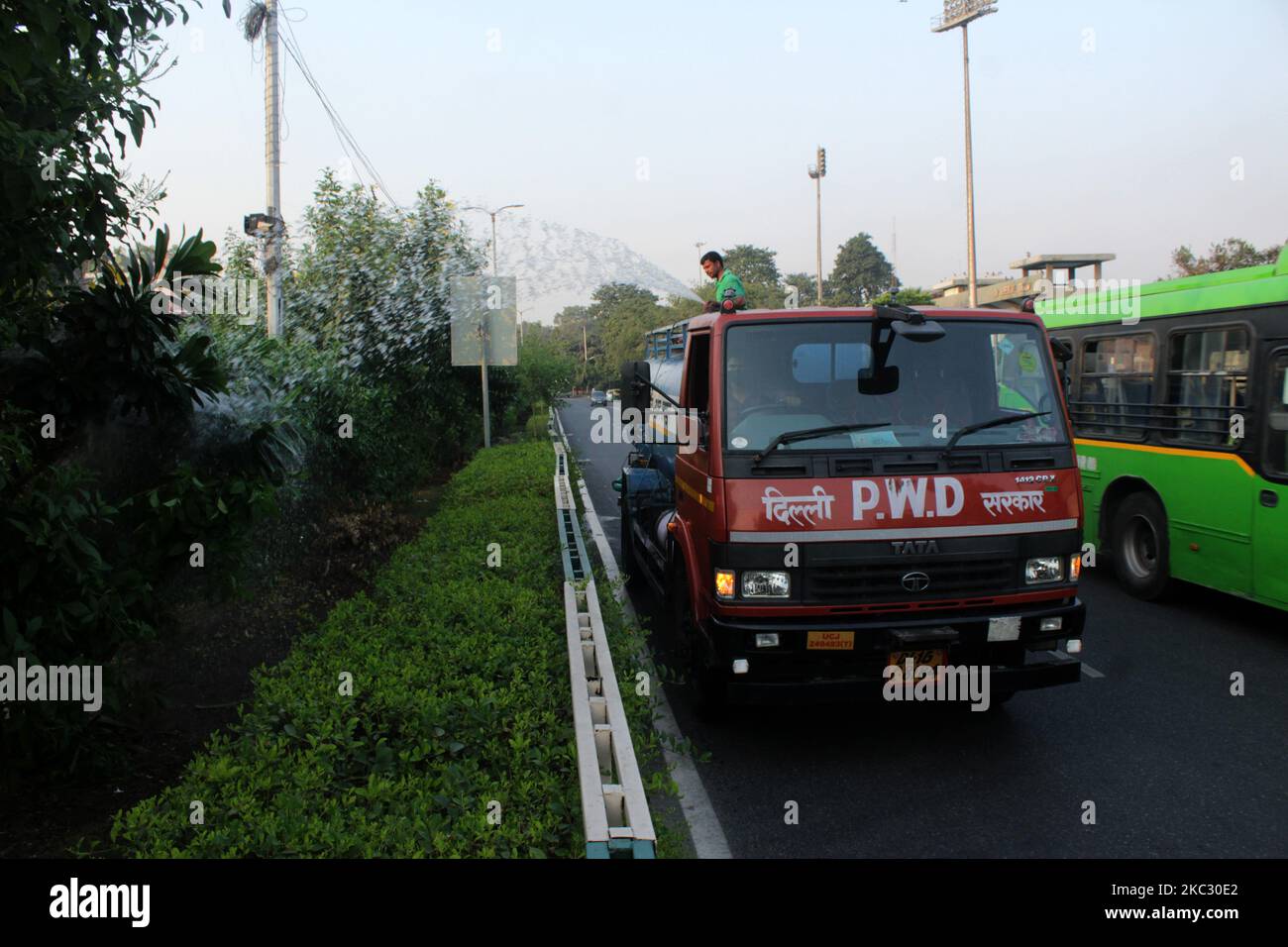 A PWD worker sprinkles water on trees in an attempt to control dust pollution at Bahadur Shah Zafar Marg on October 30, 2020 in New Delhi, India. Air quality continues to deteriorate in Delhi with the rise in pollutants in the atmosphere. Centre has introduced a new law through an ordinance that puts in place a powerful oversight body and provides for up to five years of jail term and Rs one crore fine for violators with immediate effect. (Photo by Mayank Makhija/NurPhoto) Stock Photo