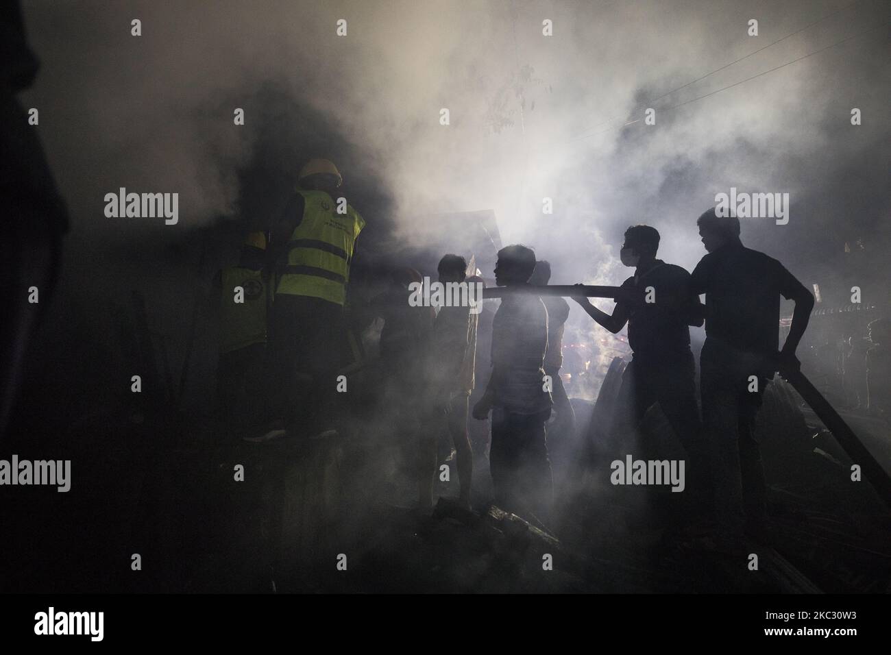 Residence and firefighters work to extinguish a fire that broke out in ...