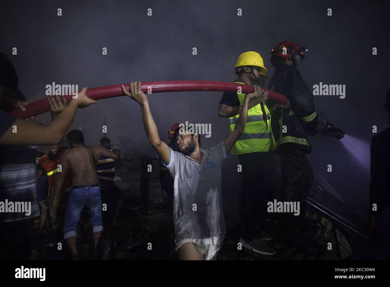 Residence and firefighters work to extinguish a fire that broke out in ...
