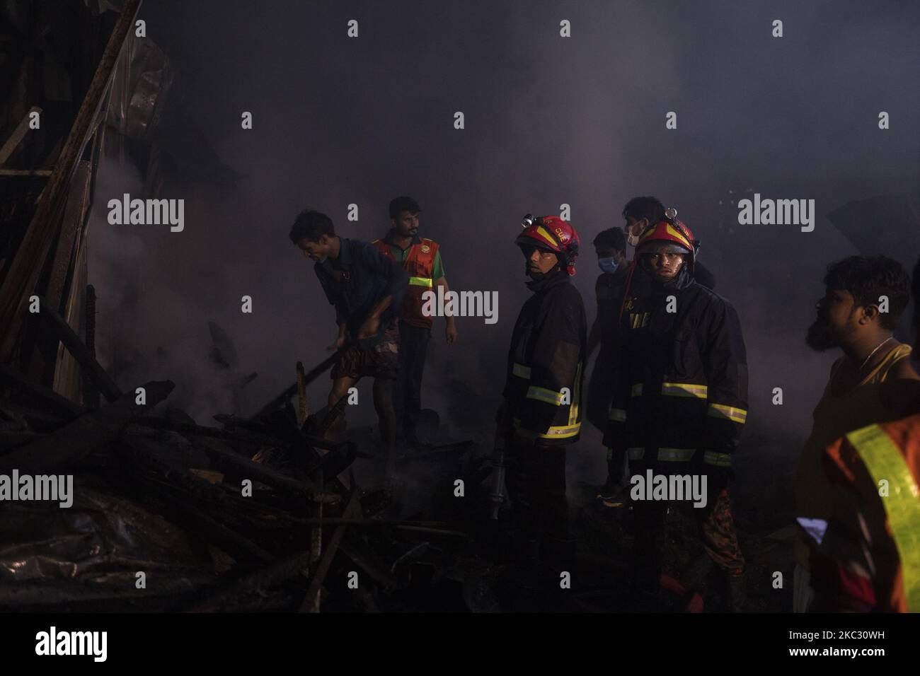 Residence and firefighters work to extinguish a fire that broke out in ...
