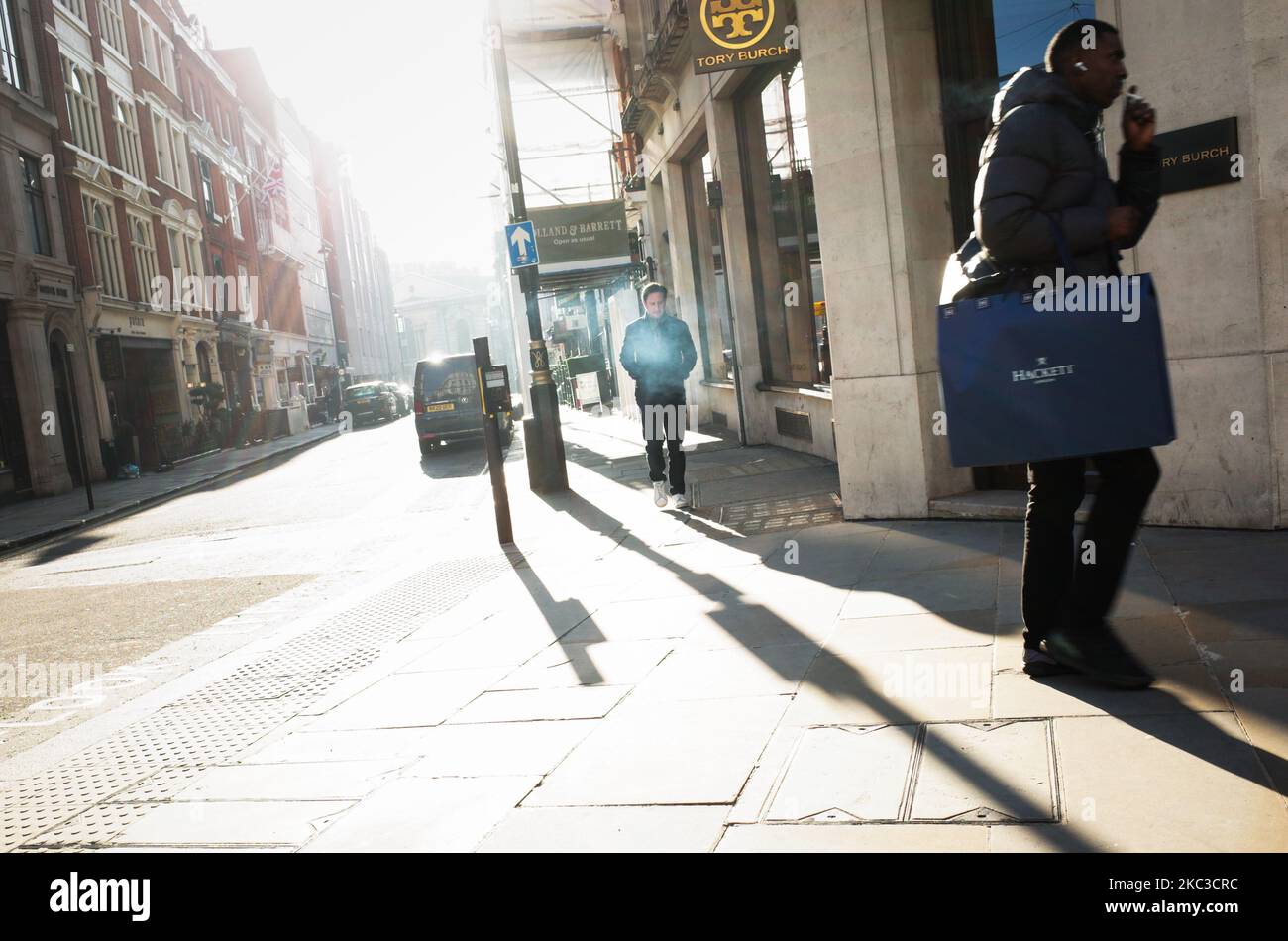 A man walks up Maddox Street as another passes by on a near-deserted Regent Street in London, England, on November 5, 2020. England today began its second national coronavirus lockdown with pubs, bars, restaurants and non-essential shops all required to close until the currently scheduled end date of December 2. People have meanwhile been told to stay home as much as possible, although schools and other educational institutions are this time being being kept open. The new shutdown was announced by British Prime Minister Boris Johnson on Saturday, citing fears that covid-19 again threatened to  Stock Photo