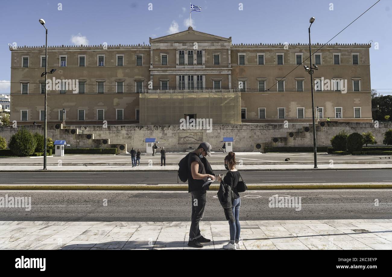 A couple reads the map at empty Syntagma square in central Athens, Greece on November 7, 2020 on the first day of a three-weeks lockdown. - Greek goverment imposed a nationwide lockdown as of November 7, to curb the spread of the Covid-19 (Photo by Dimitris Lampropoulos/NurPhoto) Stock Photo