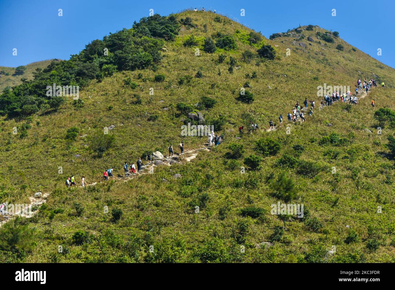Hikers queue up on the steps to Sunset Peak in Lantau, Hong Kong, China on November 7, 2020. As temperatures have become fresher, many hongkongers have headed out to the outdoors, sometimes creating real ''traffic jams'' on the mountains. (Photo by Marc Fernandes/NurPhoto) Stock Photo
