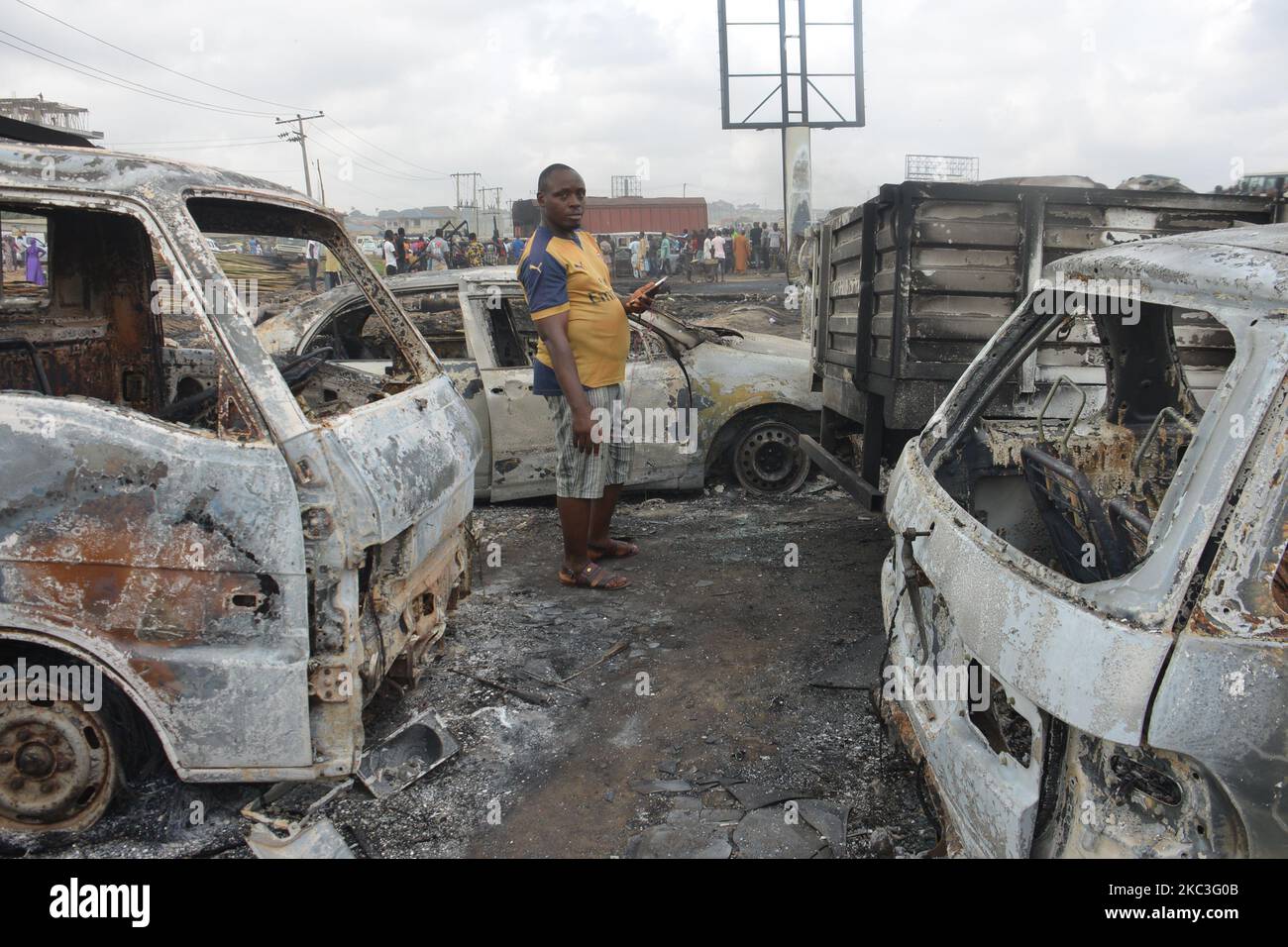 A man stand inbetween burned cars after a tanker exploded on Lagos