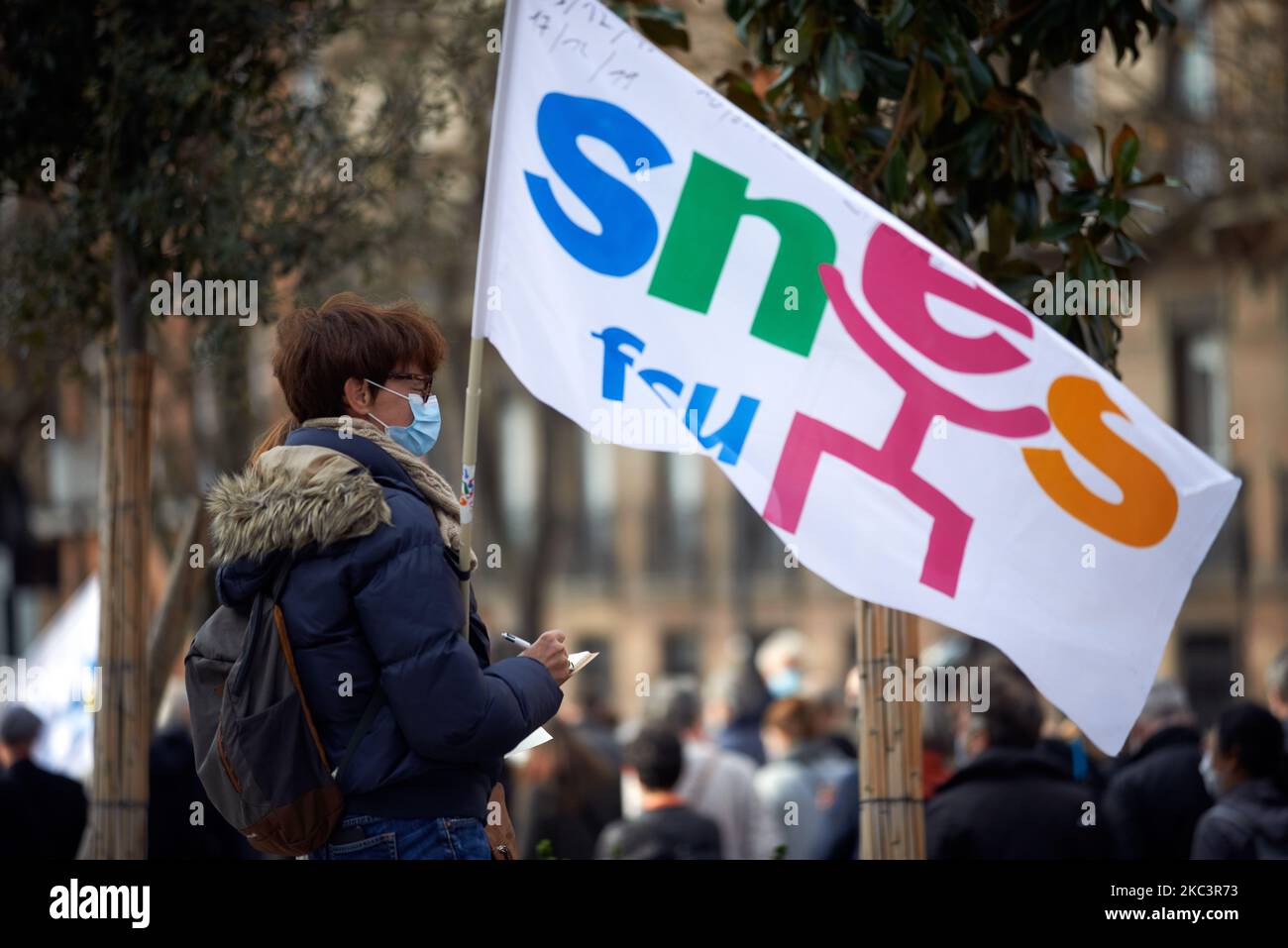 A woman holds a flag of the SNES-FSU union. Teachers protested in Toulouse for a 'health strike' they protest for their duty to protect pupils from the Covid-19 illness with Education minister sanitary protocols such as social distanciation, health risks and protectives measures. They say it's impossible to respect the measures as they must do the classroom with all pupls present. They ask to give courses by half class, one in the morning, one in the afternoon. Toulouse. France. November 10th 2020. (Photo by Alain Pitton/NurPhoto) Stock Photo