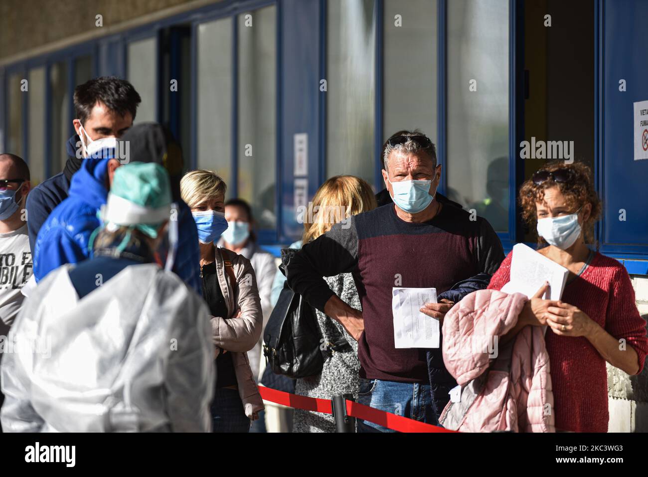 people in line waiting to swab at the swab point set up below the Euganeo Stadium. They all wear protective masks, are spaced one meter apart and are controlled and assisted by medical personnel and not by the Italian Army. Padua, 11 November 2020 With the increase in the curve of infections and consequently of the infected, the hospitals of the Veneto and specifically of Padua and Schiavonia are close to collapse. To ease the grueling workload on the shoulders of doctors and nurses, the army took to the field with its qualified personnel. Army doctors and nurses from today preside and help st Stock Photo