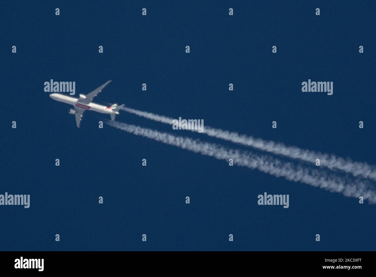 An Emirates Boeing 777 passenger aircraft flying in the blue sky at 39.000 ft from Dubai DXB International Airport in UAE to Manchester MAN in the UK flight no EK17. The overflying wide-body airplane Boeing B777-300 777-31H(ER) has the registration A6-EGV and is powered by 2x GE jet engines. Emirates is flying during the Covid-19 Coronavirus Pandemic with large wide-body planes. The overfly airliner creates contrail or chemtrail while cruising, forming a white line of condensation trail in the atmosphere behind it. Eindhoven, Netherlands on 11 November 2020 (Photo by Nicolas Economou/NurPhoto) Stock Photo