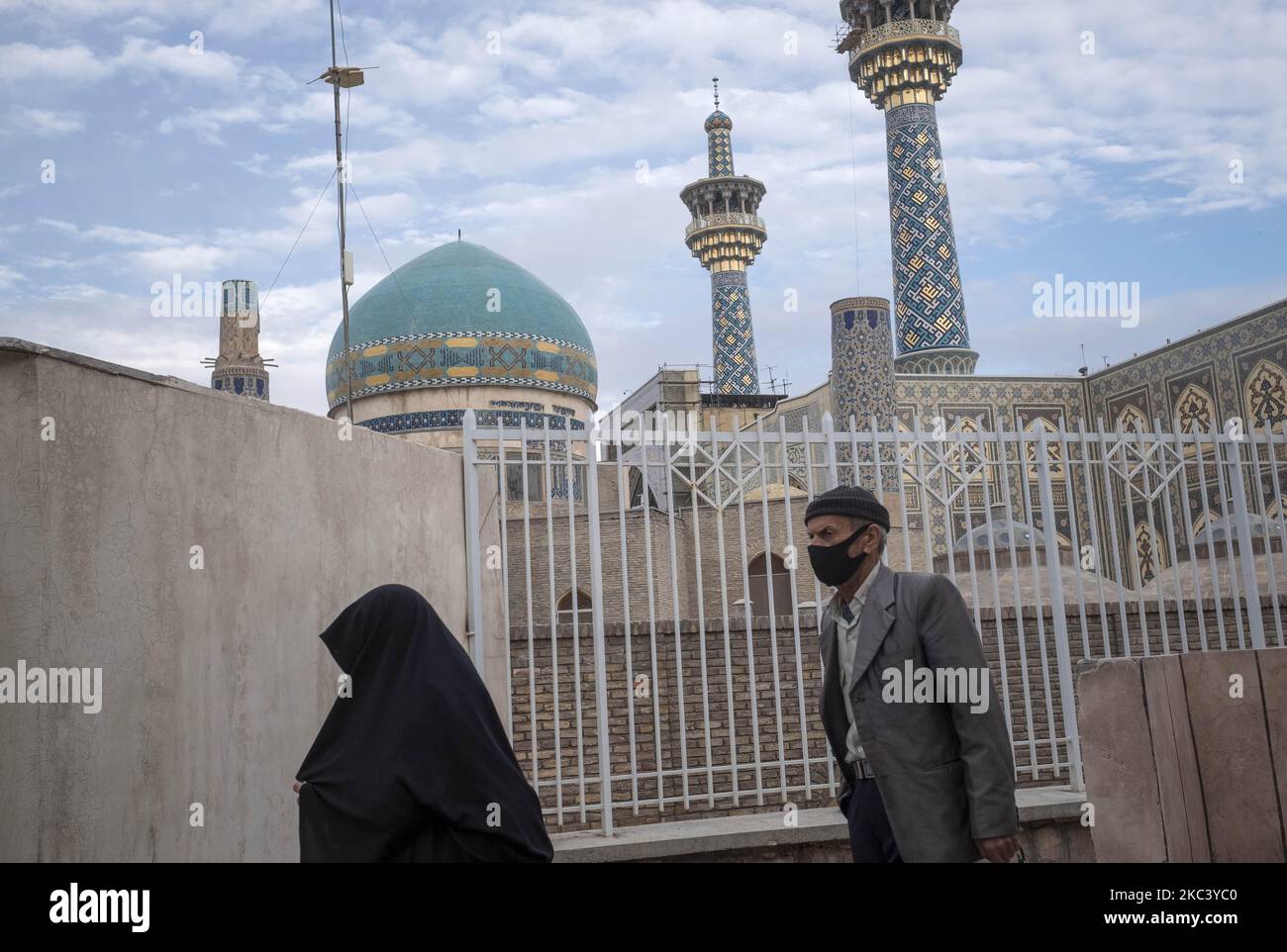 An Iranian veiled woman and an elderly man who wears a protective face ...