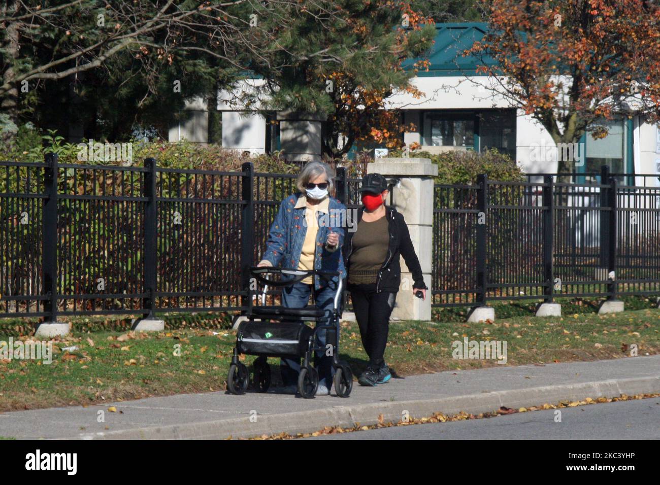 People wearing face masks as they walk along the street during the novel coronavirus (COVID-19) pandemic in Toronto, Ontario, Canada on November 12, 2020. Ontario reported 1,575 new COVID-19 cases today and 18 more deaths, setting a new single-day record for daily cases reported in a 24-hour period since the start of the pandemic. New modeling projections warn that Ontario could see 6,500 daily cases of COVID-19 by mid-December. The projections also suggest that the number of COVID-19 patients in intensive care units will exceed the 150 threshold within two weeks, overwhelming some hospitals a Stock Photo