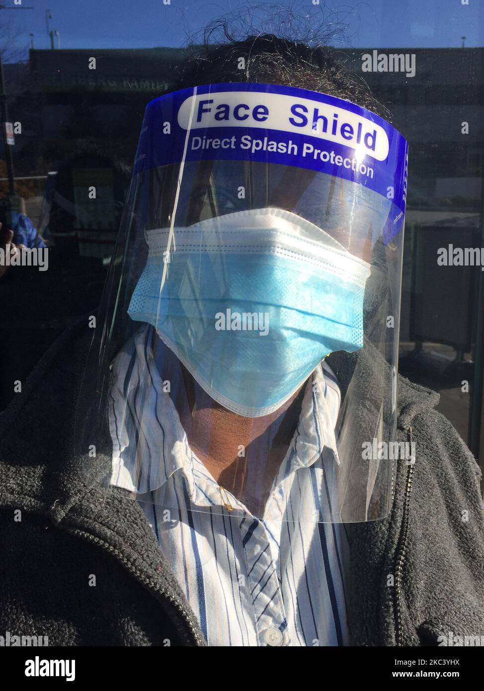 Woman wearing a plastic face shield and face mask as she waits outside North York General Hospital during the novel coronavirus (COVID-19) pandemic in Toronto, Ontario, Canada on November 12, 2020. Ontario reported 1,575 new COVID-19 cases today and 18 more deaths, setting a new single-day record for daily cases reported in a 24-hour period since the start of the pandemic. New modeling projections warn that Ontario could see 6,500 daily cases of COVID-19 by mid-December. The projections also suggest that the number of COVID-19 patients in intensive care units will exceed the 150 threshold with Stock Photo