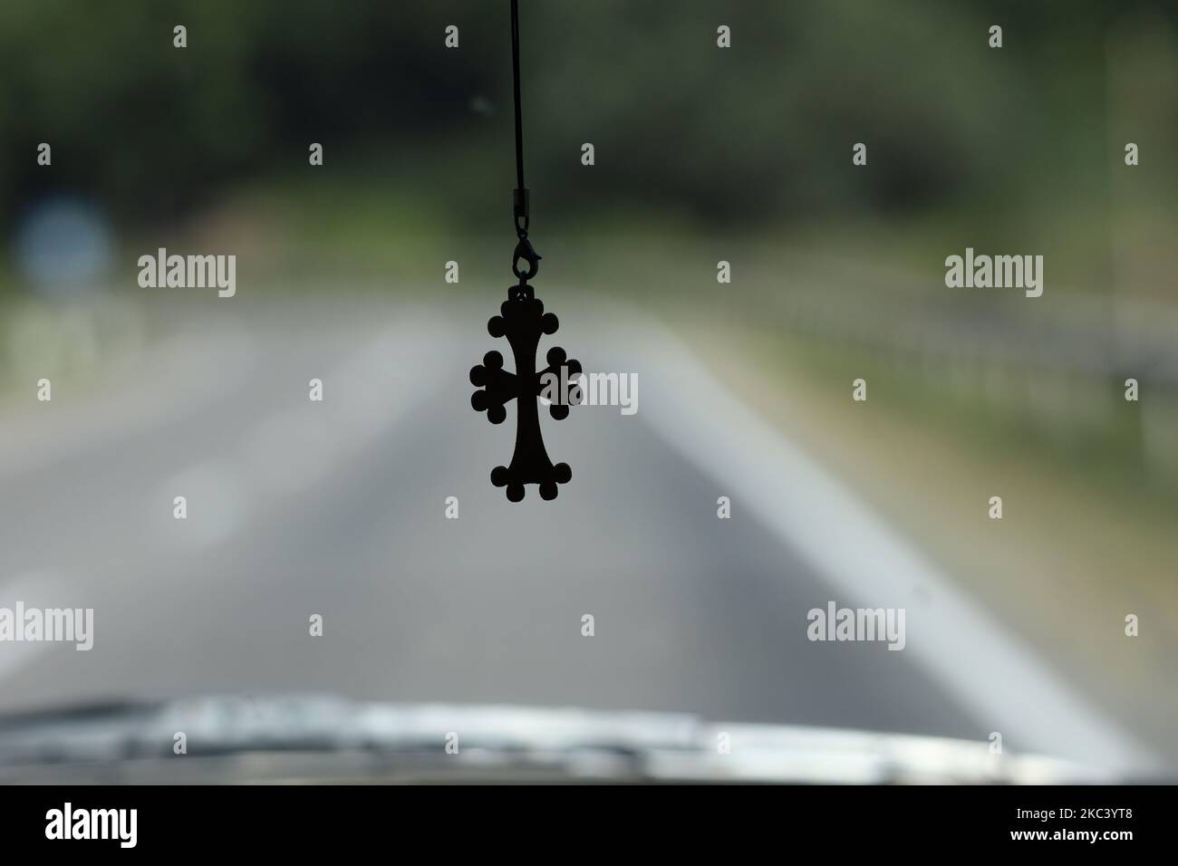 The cross hanging from the rearview mirror of the car, closeup Stock