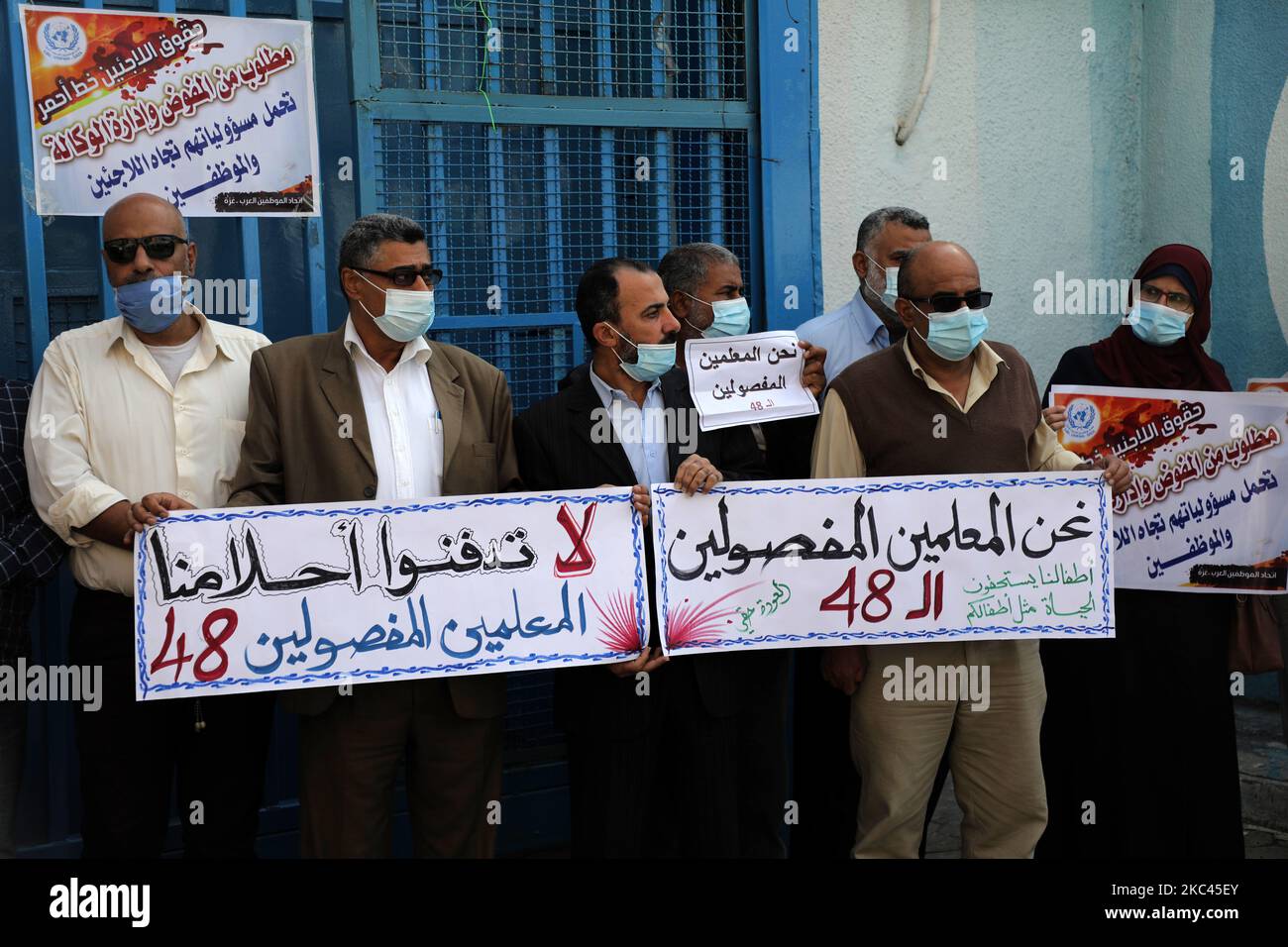 Palestinian UNRWA emplyees, mask-clad due to the COVID-19 coronavirus pandemic, protest outside the headquarters of the United Nations Relief and Works Agency for Palestine Refugees in the Near East (UNRWA) in Gaza City on November 17, 2020 against the reduction of their salaries. financial crisis' ever faced by the UN's agency for Palestinian refugees could lead to 'disaster' in the Gaza Strip and insecurity in Lebanon, the organisation's chief has warned. (Photo by Majdi Fathi/NurPhoto) Stock Photo