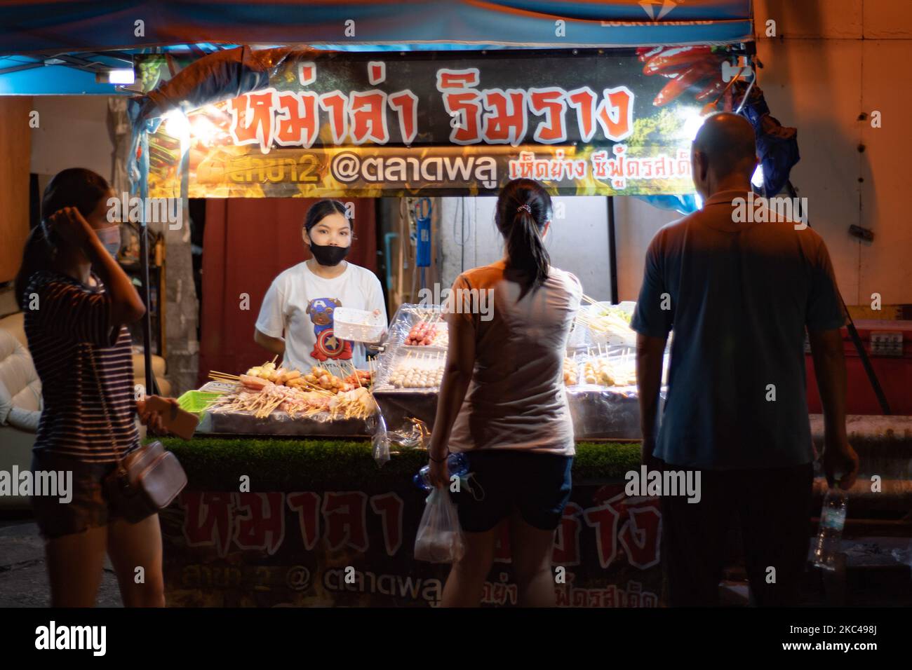 A street food vendor selling food at her street food stall in Talat