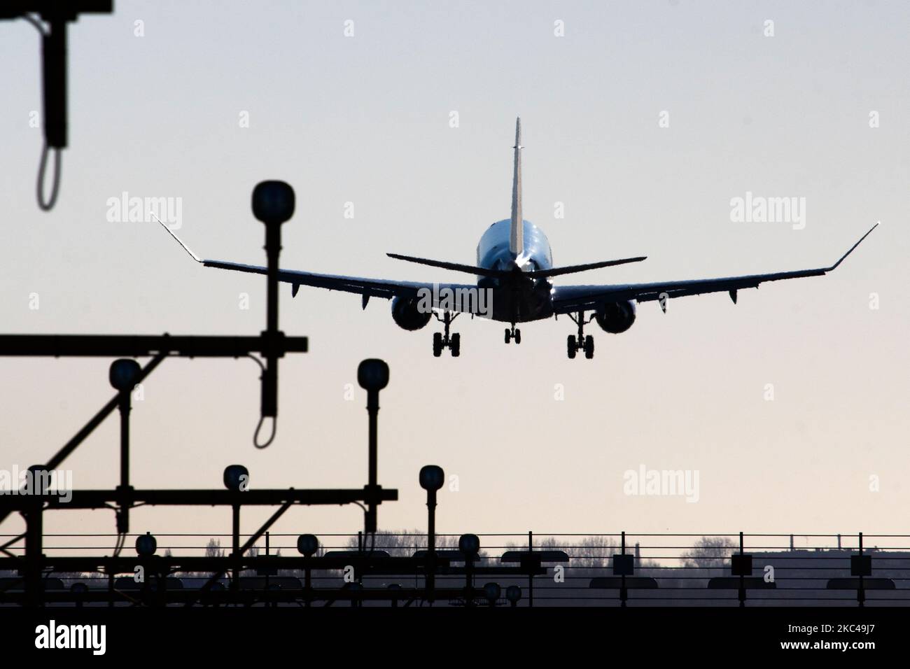 Rear view of various aircraft landing behind the runway lights in Amsterdam Schiphol AMS EHAM International Airport in The Netherlands. The world passenger traffic declined during the coronavirus covid-19 pandemic era with the industry struggling to survive. Amsterdam, Netherlands on November 18, 2020 (Photo by Nicolas Economou/NurPhoto) Stock Photo