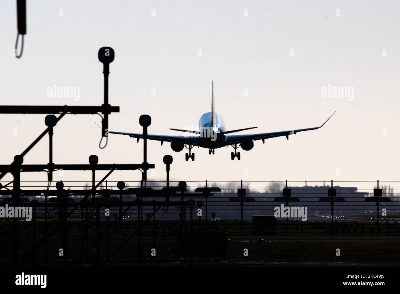 Rear view of various aircraft landing behind the runway lights in Amsterdam Schiphol AMS EHAM International Airport in The Netherlands. The world passenger traffic declined during the coronavirus covid-19 pandemic era with the industry struggling to survive. Amsterdam, Netherlands on November 18, 2020 (Photo by Nicolas Economou/NurPhoto) Stock Photo