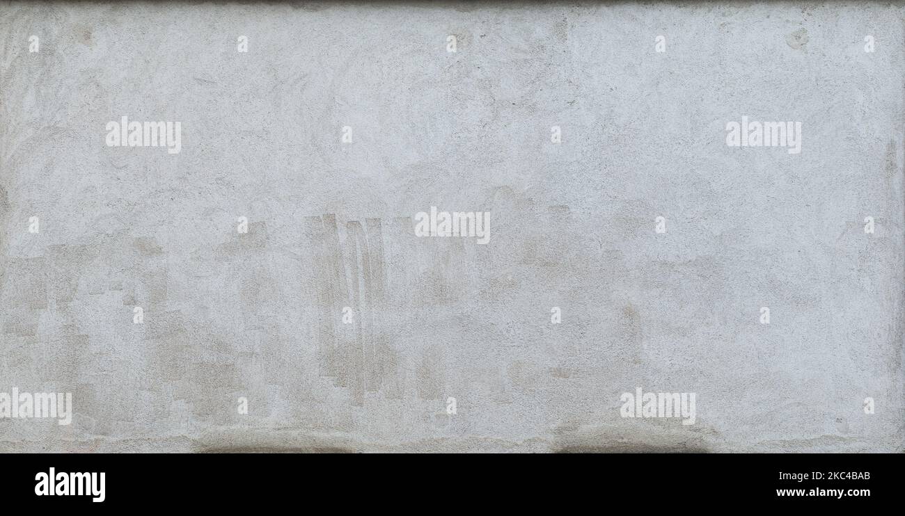 Front view of a plastered gray stone wall with stains from graffiti removal. Abstract high resolution full frame textured background. Stock Photo