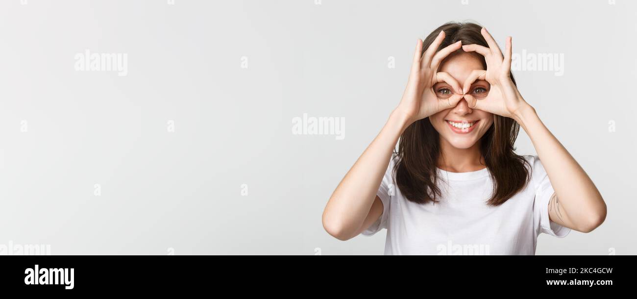Closeup of happy smiling girl looking through okay gestures