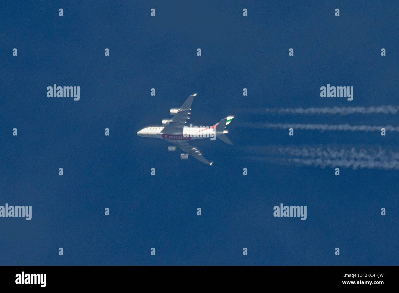 Emirates Airbus A380 double-decker aircraft as seen fly at 40.000 feet over the Netherlands. The largest passenger plane in the world, the wide-body long haul airplane has the registration A6-EUT and is powered by 4x RR jet engines. The airplane departed from Dubai DXB, UAE and is flying to London Heathrow LHR in the UK, flight no EK1. Emirates relaunched flights with the A380 after the fleet was grounded because of the Coronavirus travel restrictions. The overfly airliner creates contrail or chemtrail while cruising, forming a white line of condensation trail in the atmosphere behind it. . Em Stock Photo