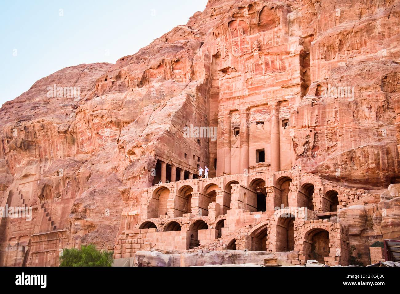 Tourist stand by Royal tombs structures in ancient city of Petra, Jordan. UNESCO World Heritage Site Stock Photo