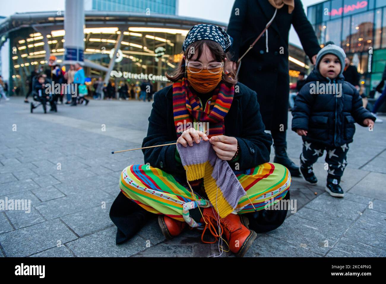 An Extinction Rebellion activist is knitting in front of the biggest shopping mall in The Netherlands during the 'Circus protest' against Black Friday, in Utrecht, on November 27th, 2020. (Photo by Romy Arroyo Fernandez/NurPhoto) Stock Photo