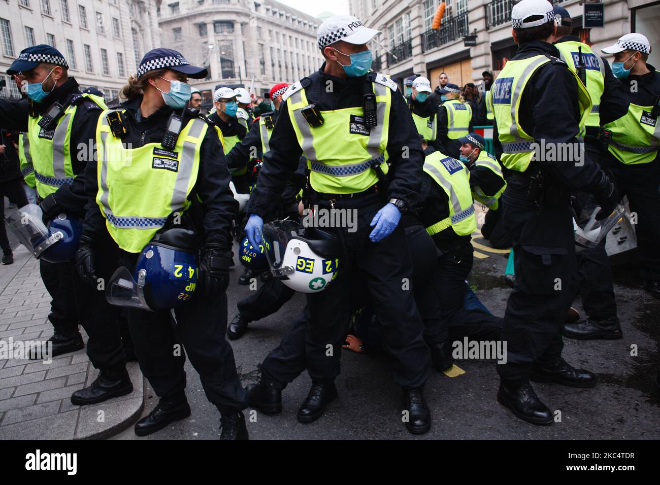 Anti-lockdown activists scuffle with police officers on Regent Street during a demonstration in London, England, on November 28, 2020. In an evening update the Metropolitan Police announced it had made 155 arrests over the course of the day's demonstrations, for offences including breaches of coronavirus regulations, assault on police and possession of drugs. London is to return to 'Tier 2' or 'high alert' covid-19 restrictions once the current England-wide coronavirus lockdown ends next Wednesday. All three of the tiers, assigned to local authorities across England, have been strengthened sin Stock Photo
