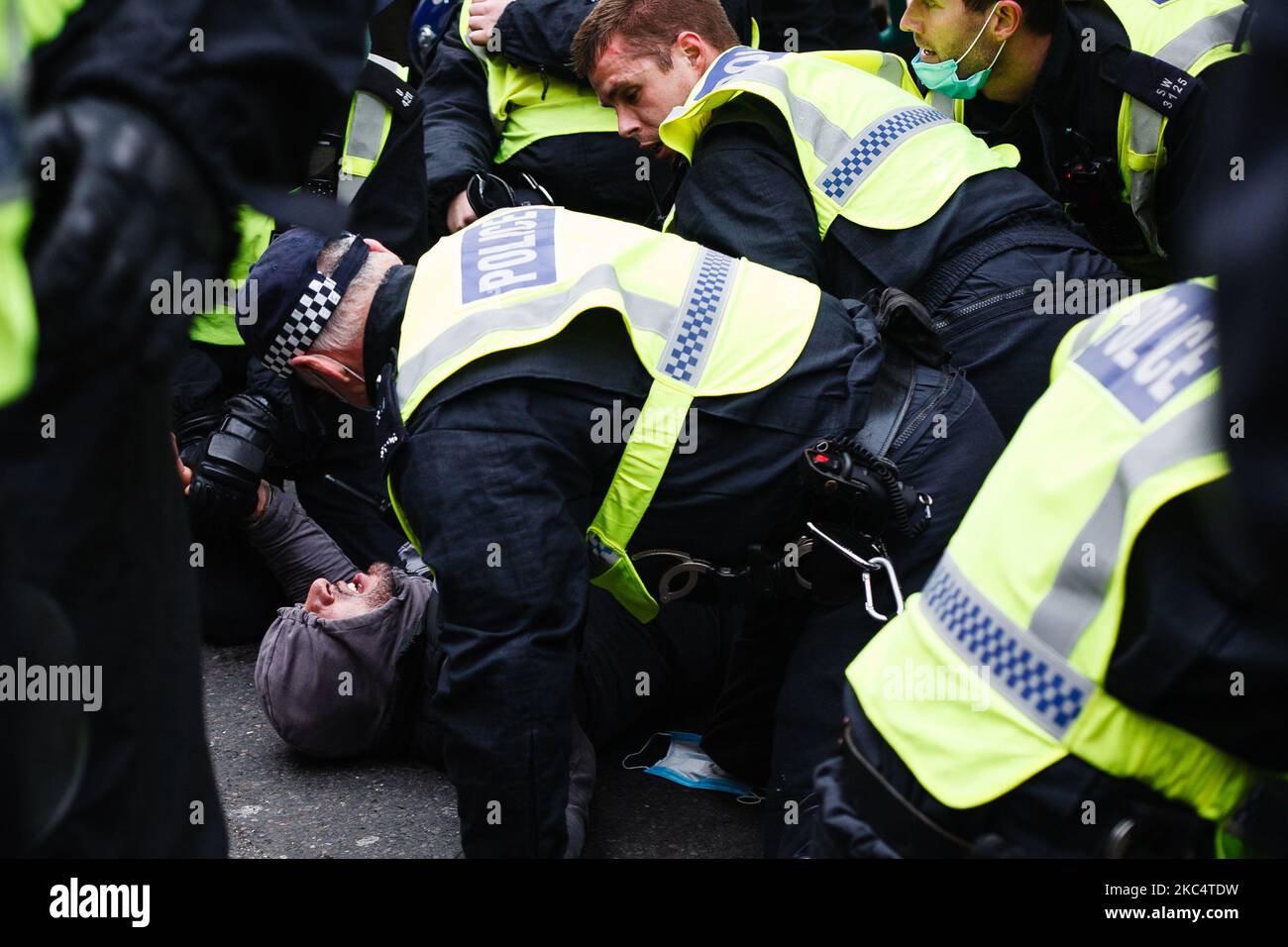 Police officers pin anti-lockdown activists to the ground on Regent Street during a demonstration in London, England, on November 28, 2020. In an evening update the Metropolitan Police announced it had made 155 arrests over the course of the day's demonstrations, for offences including breaches of coronavirus regulations, assault on police and possession of drugs. London is to return to 'Tier 2' or 'high alert' covid-19 restrictions once the current England-wide coronavirus lockdown ends next Wednesday. All three of the tiers, assigned to local authorities across England, have been strengthene Stock Photo