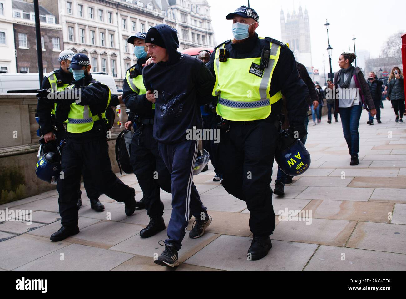 An anti-lockdown activist is arrested on Parliament Street during a demonstration in London, England, on November 28, 2020. In an evening update the Metropolitan Police announced it had made 155 arrests over the course of the day's demonstrations, for offences including breaches of coronavirus regulations, assault on police and possession of drugs. London is to return to 'Tier 2' or 'high alert' covid-19 restrictions once the current England-wide coronavirus lockdown ends next Wednesday. All three of the tiers, assigned to local authorities across England, have been strengthened since the lock Stock Photo