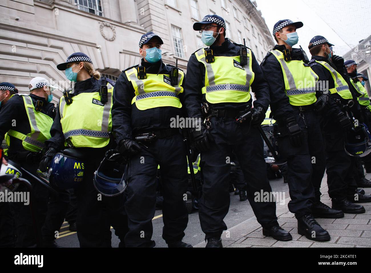 Police officers in riot gear form a cordon amid scuffles with activists on Regent Street during an anti-lockdown demonstration in London, England, on November 28, 2020. In an evening update the Metropolitan Police announced it had made 155 arrests over the course of the day's demonstrations, for offences including breaches of coronavirus regulations, assault on police and possession of drugs. London is to return to 'Tier 2' or 'high alert' covid-19 restrictions once the current England-wide coronavirus lockdown ends next Wednesday. All three of the tiers, assigned to local authorities across E Stock Photo