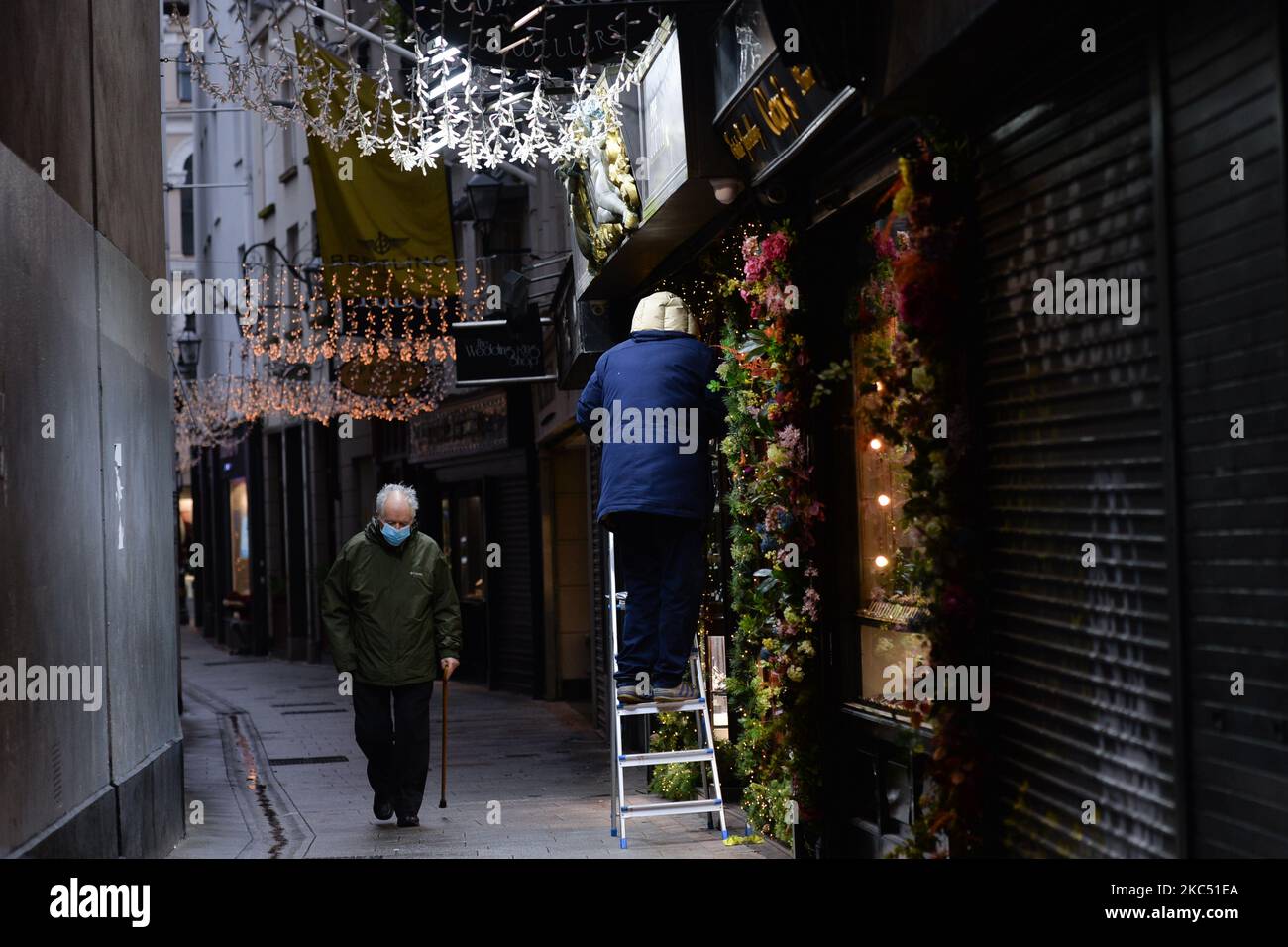 A man seen decorating his shop with Christmas lights, in Dublin city